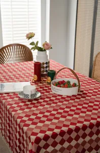 Red and beige checkered tablecloth with elegant gold lace trim for dining table and home decor.