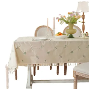 Elegante katoenen tafellaken met fijn geborduurd bloemmotief en decoratieve franjes rand.