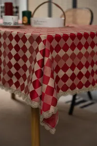 Jacquard diamond tablecloth detail showing red beige check and delicate gold lace edge.