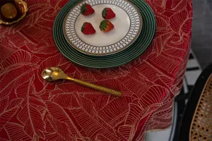 Close-up view of red jacquard waterproof round tablecloth featuring elegant gold leaf pattern.