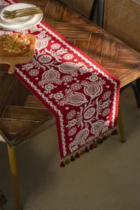 Red jacquard table runner with tassels, festive geometric design for dining table decor.
