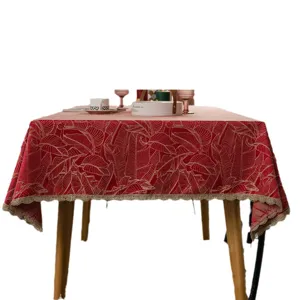 Red and gold jacquard tablecloth with elegant leaf pattern and lace trim for festive dining.