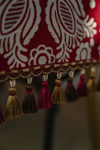 Red jacquard table runner with intricate tassels and festive geometric patterns for new year.