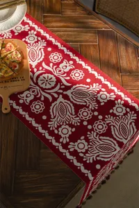Red jacquard table runner with white geometric floral pattern, festive home decor.