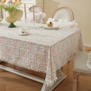 Tovaglia rettangolare in jacquard di cotone francese con motivo floreale e pompon.