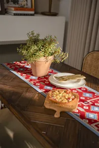 Red festive geometric table runner detail, elegant jacquard fabric for dining room decor.