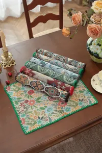 Vintage woven table runner detail, paisley jacquard pattern with green shell edge design.