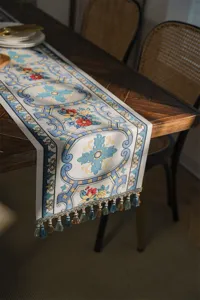 Elegant jacquard table runner with intricate floral patterns and delicate tassels for home decor.