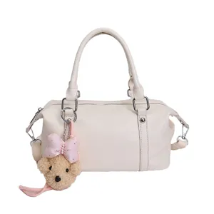 White boston bag for women, stylish shoulder crossbody bag with cute plush bear pendant.