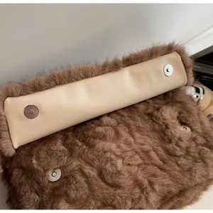 Détail de sac porté épaule en peluche marron avec fausse fourrure douce et fermoir aimanté.