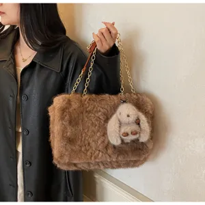 Cozy plush shoulder bag detail featuring soft faux fur, chunky gold chain strap, and cute bunny charm.