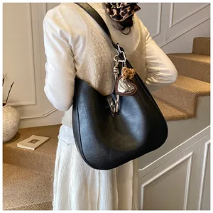 Black slouchy shoulder bag for women, stylish hobo crossbody purse with chic charms.