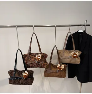Retro suede shoulder bag for women, chic winter commuting tote with chic pendant detail.