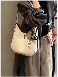 Stylish white leather underarm shoulder bag for women, elegant hobo handbag with lock hardware.