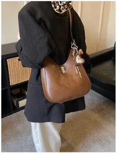 Detail view of a stylish brown leather shoulder bag, chic underarm design for women daily commute.