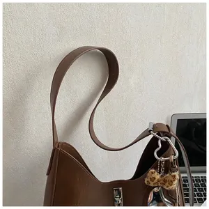 Brown leather underarm shoulder bag detail, stylish hobo bag with turn lock closure.