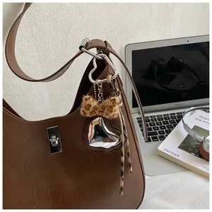 Brown leather shoulder hobo bag with trendy leopard bow and heart mirror charm detail.