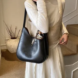 Women's black shoulder underarm hobo bag, stylish winter commuter handbag with charm.
