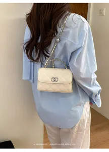 Detail shot of the white quilted chain bag worn on shoulder, elegant retro vibe style.