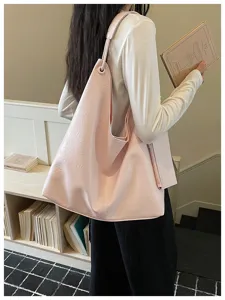 Detailed view of women casual pink soft leather shoulder tote bag in daily indoor scene.