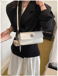 Elegant women shoulder crossbody bag with metallic twist lock and cute bear pendant detail.