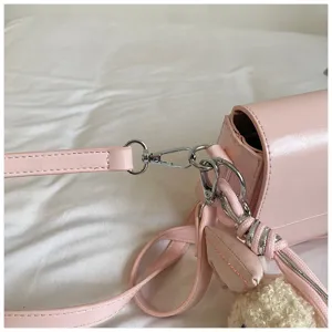 Detail shot of the pink women's shoulder bag showcasing metal hardware and strap connection.