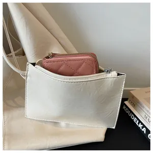 Detail shot of a minimalist retro soft leather tote bag with a chic pink quilted wallet inside.