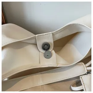 Minimalist soft leather tote bag detail view, elegant off-white shoulder commute bag.