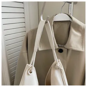 Minimalist soft leather shoulder bag detail shot showing smooth texture and strap construction.