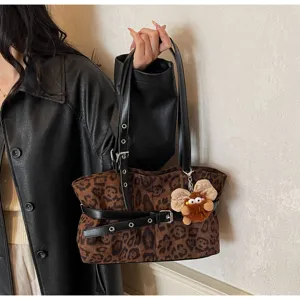 Leopard print suede shoulder bag detail shot with leather strap and cute plush charm.