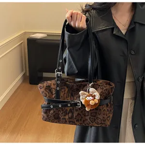 Detailed view of the winter retro leopard print suede shoulder bag with black leather straps.