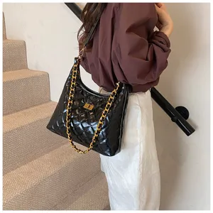 Detail shot of a chic black quilted shoulder bag with chunky gold chain for women commuting.