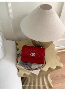 Detail shot of the red quilted chain bag showing the classic flap design and metallic strap.