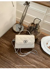 Elegant quilted design detail of white leather shoulder bag with silver chain strap and chic lock.