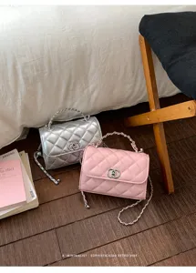 Detailed view of fashionable quilted chain shoulder bags in silver and pink colors with chic locks.