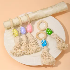 Portatovaglioli in perle di legno con colorate uova di Pasqua e nappe per la tavola.