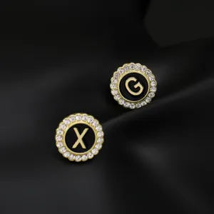 Close-up detail of vintage round letter brooch with sparkling rhinestones and black enamel center.