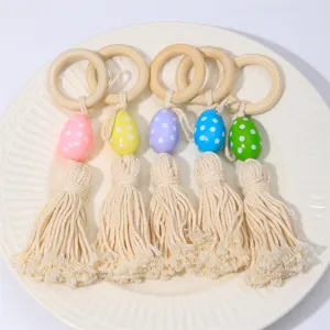 Portatovaglioli pasquali in legno con uova colorate a pois e nappe fatte di cotone.