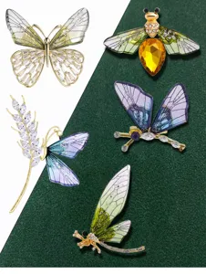 Exquisite crystal insect and plant brooch details, featuring delicate butterfly and bee.