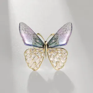 Exquisite butterfly brooch detail featuring gradient purple wings and sparkling crystal accents.