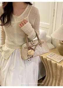 Sac à main coquille rétro minimaliste élégant pour femme, sac en cuir beige chic.