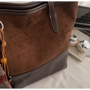 Detailed view of women's large capacity contrast suede and leather tote shoulder bag.