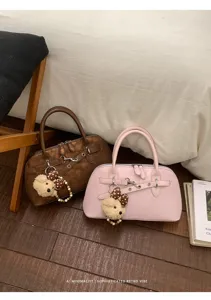 Vue détaillée de sacs à main rétro marron et rose ornés de charmants pendentifs.