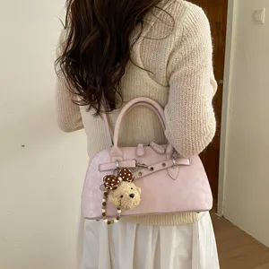 Chic sac à bandoulière rose coquillage pour femmes, avec pendentif d'ours et design élégant.