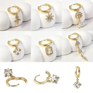 Close-up details van 18k vergulde geometrische zirkoon hanger huggie oorbellen set voor dagelijks.