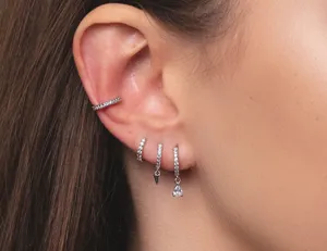 Primo piano dettagliato di eleganti orecchini a cerchio pavé in zirconia e cuff set.