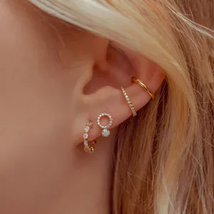 Ensemble de pinces d'oreille dorées tendance et boucles en zircon avec des pierres colorées.