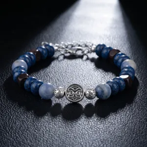 Bracelet de perles en pierres bleues avec bois et argent, vue détaillée du pendentif unique.