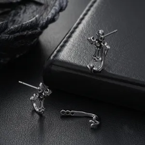 Detailed view of vintage silver cross earrings with zircon details, retro punk style men jewelry.