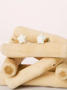 Detailed view of elegant white enamel star earrings crafted with delicate gold metal finish.